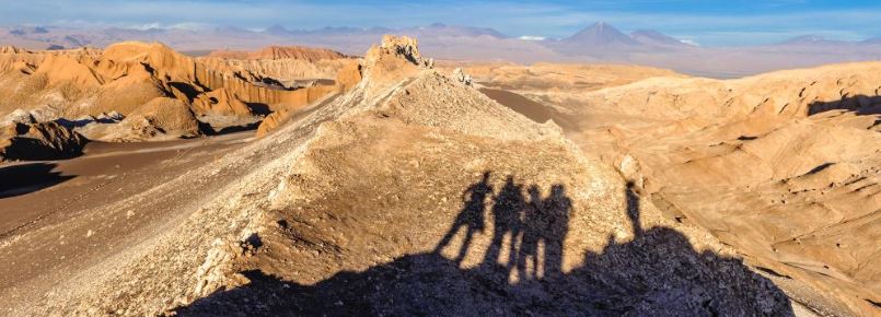 A desert horizon with the shadows of a group of 5